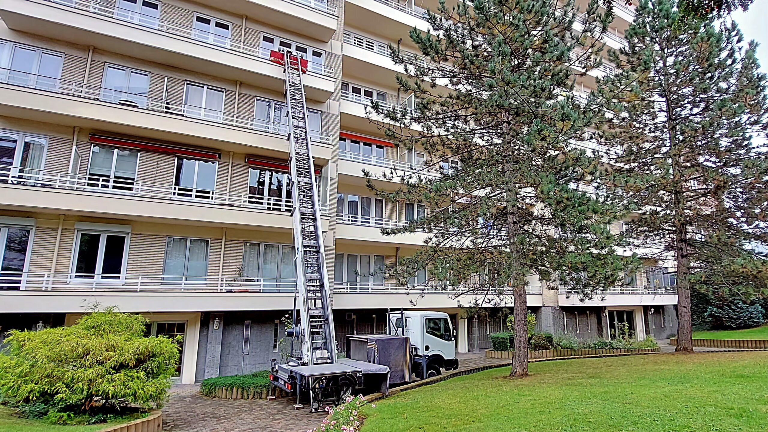 Lift de déménagement déployé sur toute sa hauteur vers un grand immeuble à appartements, à Uccle