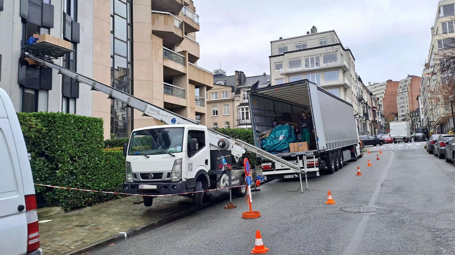 Lift de déménagement Ôlift.be vers un immeuble à balcons, semi-remorque chargée de mobilier, dans le centre de Bruxelles